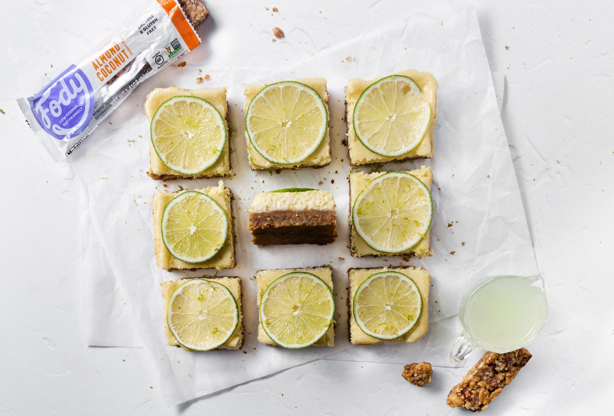 Low FODMAP Gluten-Free Key Lime Cheesecake Bars next to a Fody Snack Bar