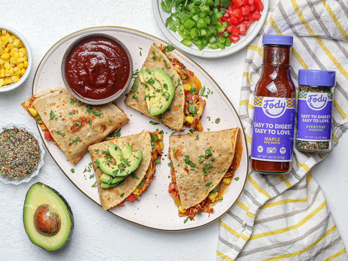 Low FODMAP quesadillas with avocado and cilantro beside Fody Maple BBQ Sauce and Low FODMAP Everyday Seasoning.