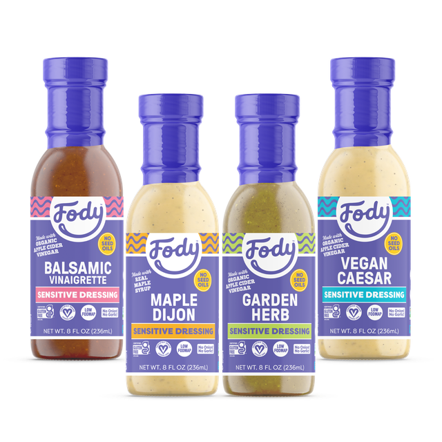  Four bottles of Fody Sensitive Dressings—Balsamic Vinaigrette, Maple Dijon, Garden Herb, and Vegan Caesar—made with apple cider vinegar and no seed oils.