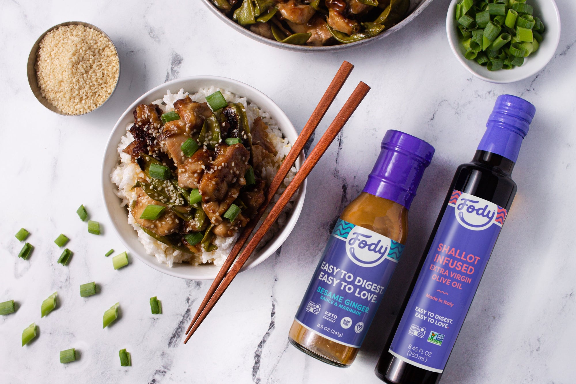Fody's Low FODMAP Sesame Ginger Chicken with Coconut Rice next to Fody Olive Oil and Fody Sesame Ginger Sauce
