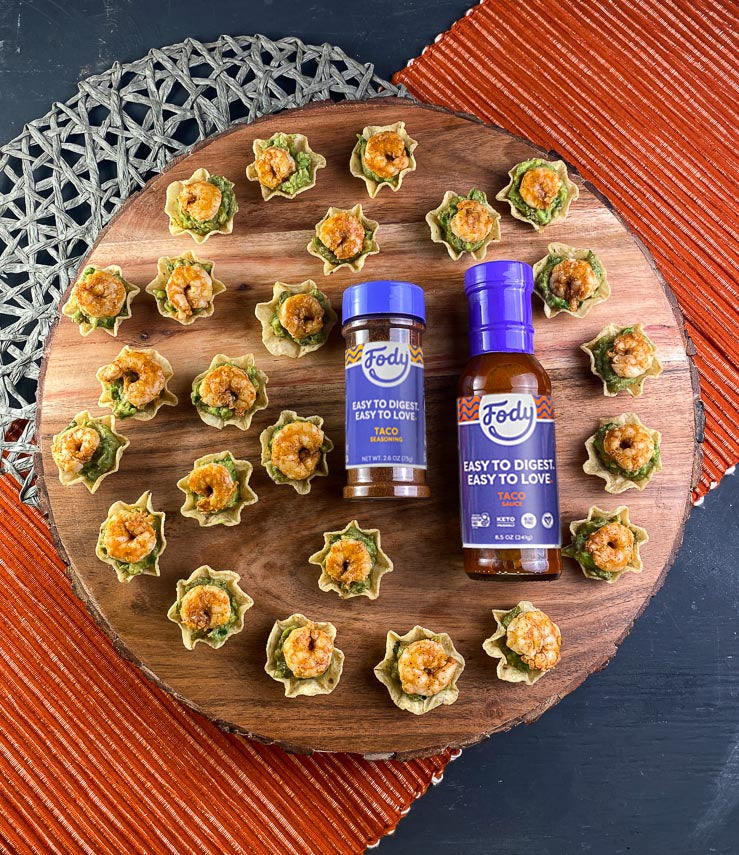 Low FODMAP shrimp bites with guacamole next to Fody's Low FODMAP seasoning and Low FODMAP taco sauce