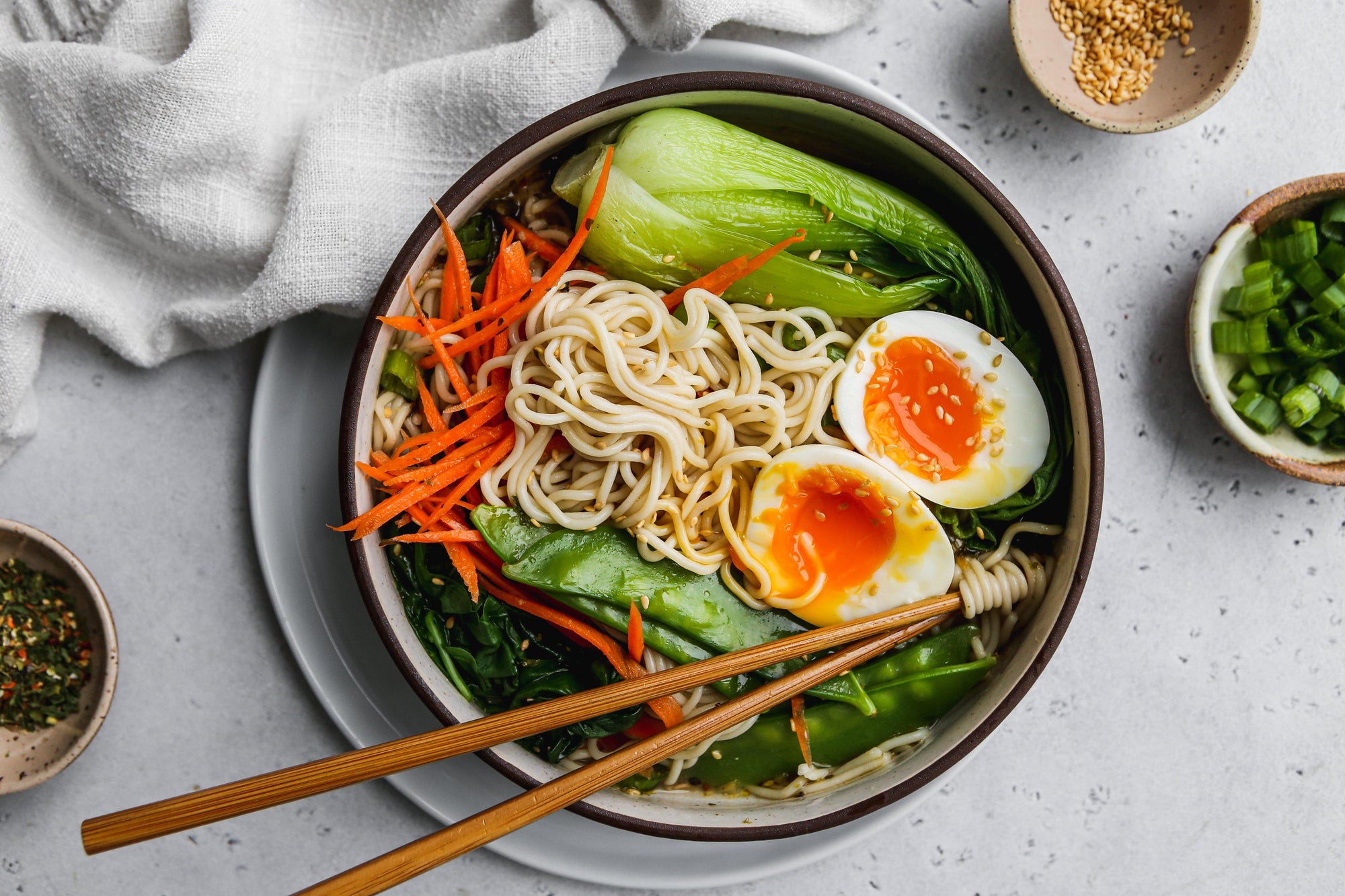A bowl of homemade ramen with noodles, bok choi, snow peas and eggs.