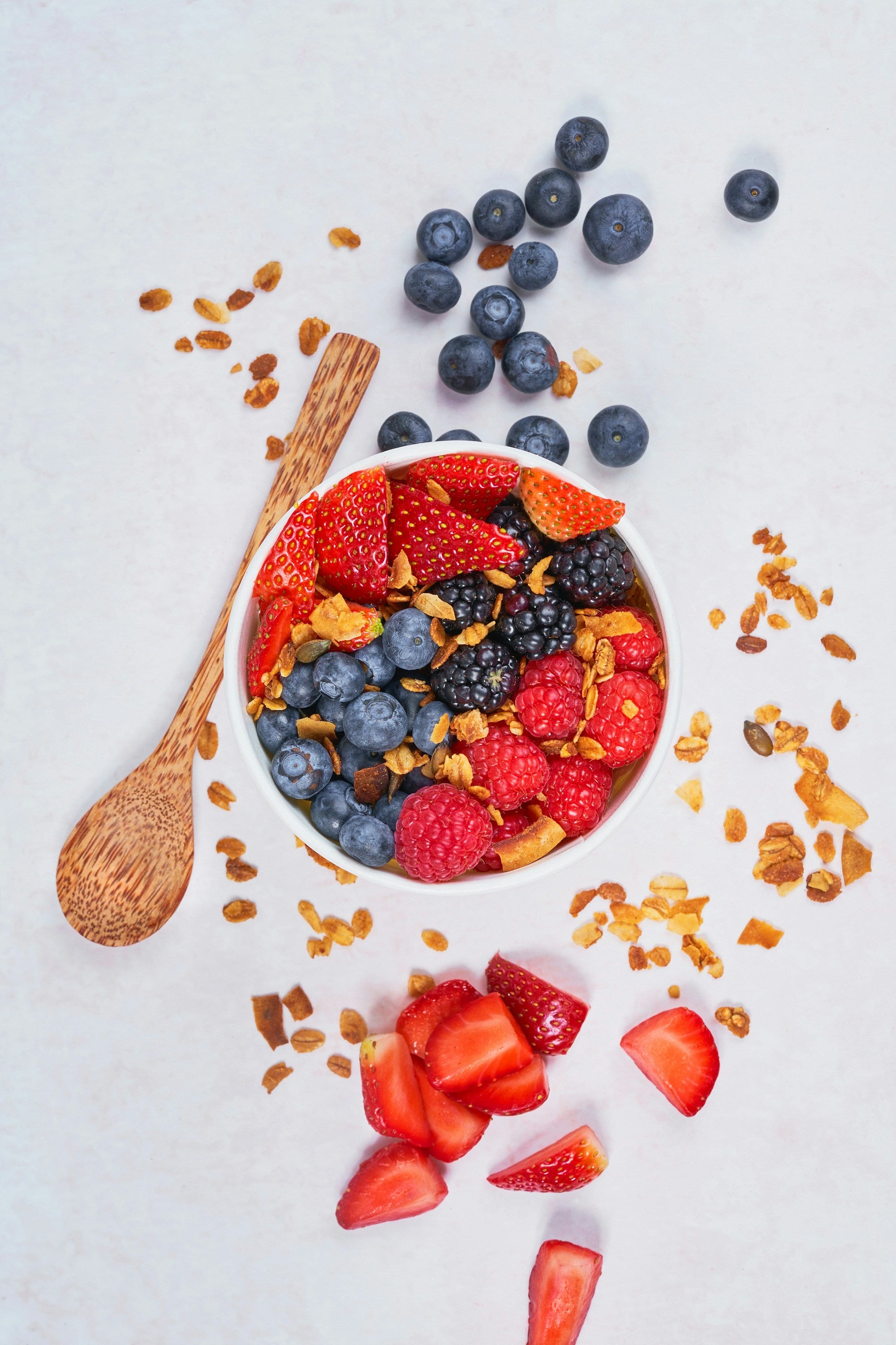 Fresh strawberries and blueberries in a white bowl — Low FODMAP fruits for GERD and IBS management 