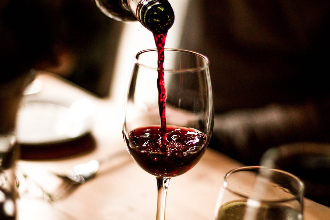 What’s the deal with alcohol and gut health? Image: red wine being poured into a wine glass.